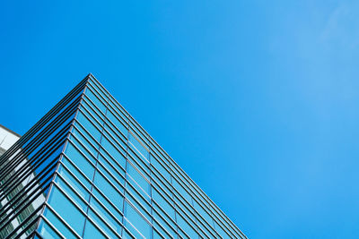 Low angle view of modern building against clear blue sky