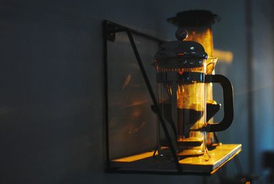 Close-up of french press on table in darkroom