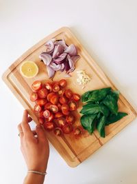 High angle view of person holding fruits on cutting board