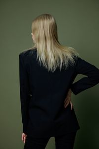 Rear view of woman standing against black background