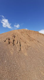 View of arid landscape against blue sky