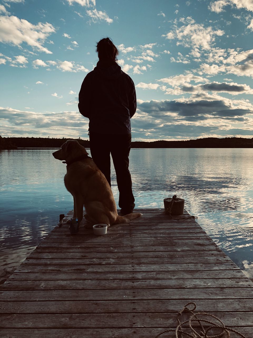 MAN WITH DOG ON PIER AGAINST SKY