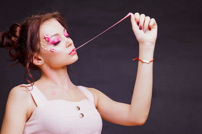 Midsection of young woman against black background