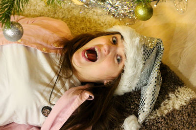 Portrait of crazy surprised youth brunet woman 20-25 years wearing white santa hat and pink shirt. 