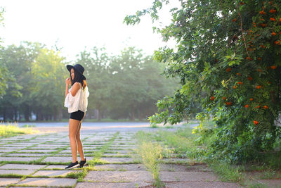 Full length rear view of woman standing on footpath