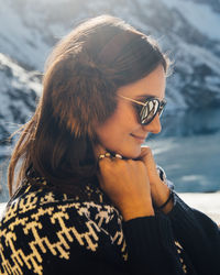 Portrait of woman wearing sunglasses at beach during winter