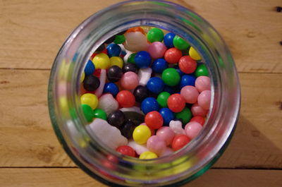 High angle view of multi colored candies in jar on table