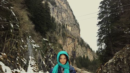 Woman in warm clothes standing against mountain