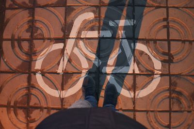 Low section of man standing on tiled floor