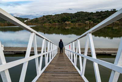 Rear view of man standing on footbridge