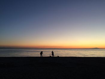 Silhouette of tourists on beach