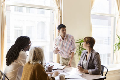 Businessman giving presentation to colleagues in office