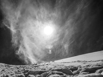 Scenic view of snow covered mountains against bright sun