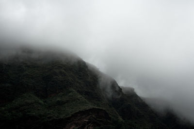 Low angle view of mountains in foggy weather