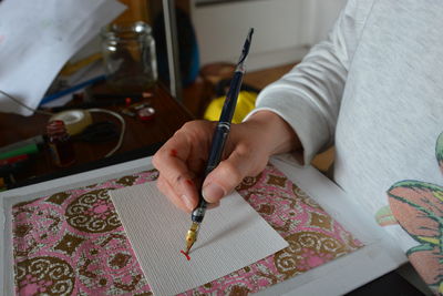 Midsection of woman writing on paper