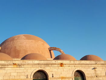 Low angle view of historical building against clear blue sky