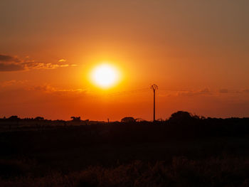 Scenic view of silhouette field against sky during sunset