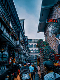 People on street amidst buildings in city