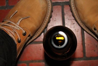 Cropped image of man with beer bottle on footpath