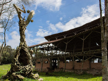 Abandoned building by trees against sky