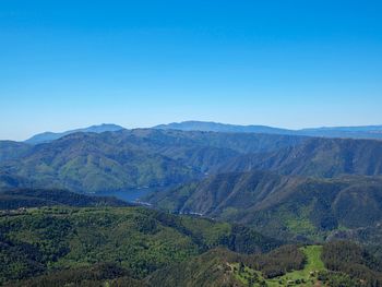 Scenic view of mountains against clear blue sky