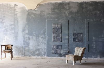 Empty chairs and against wall in empty room