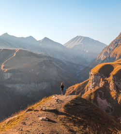 Rear view of man looking at mountain against sky