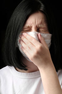 Close-up portrait of a woman covering face