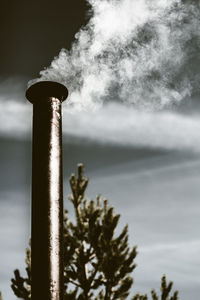 Low angle view of smoke stack against sky