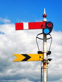 Low angle view of road sign against sky