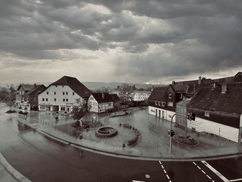 High angle view of buildings by street against sky