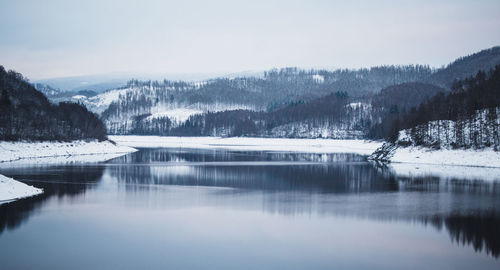 Scenic view of lake against sky during winter