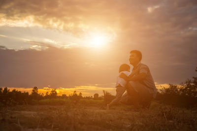 People on field against sky during sunset