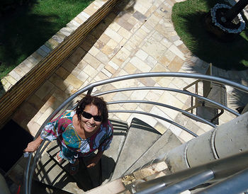 High angle view of mid adult woman standing on spiral staircase