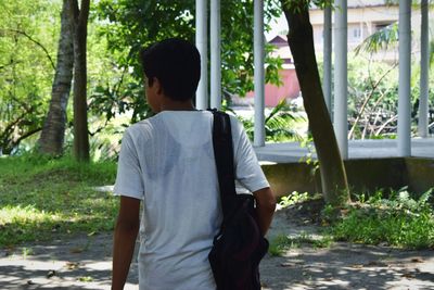 Rear view of man standing against trees