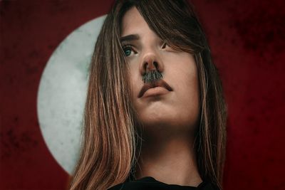 Portrait of beautiful young woman against wall