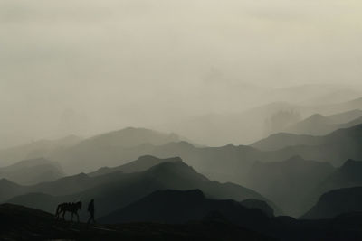 Silhouette mountain range against sky