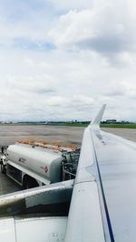 Airplane flying over runway against sky