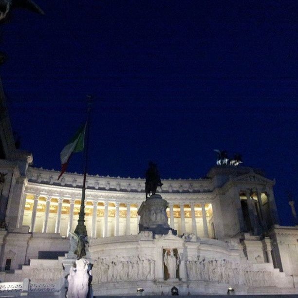 architecture, statue, human representation, built structure, sculpture, art and craft, art, building exterior, creativity, low angle view, sky, illuminated, architectural column, history, animal representation, famous place, night, clear sky