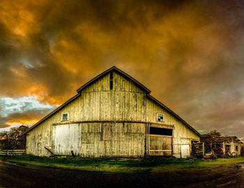 Built structure on field against cloudy sky
