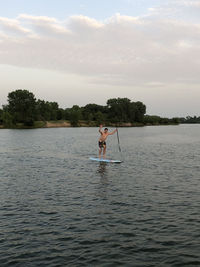 Man surfing in lake against sky