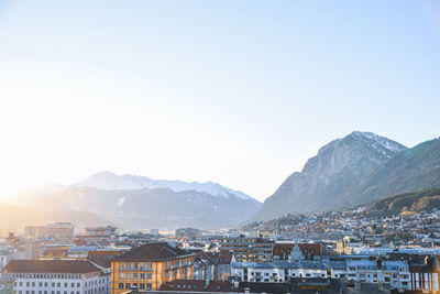 Townscape by mountains against clear sky