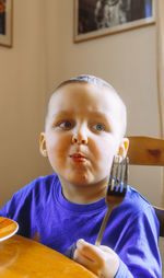 Close-up of cute boy eating food at home