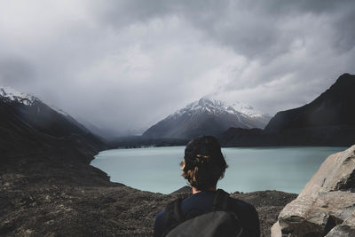 Man looking at lake against mountain range