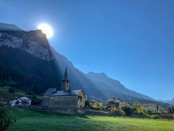 Scenic view of building by mountains against clear sky