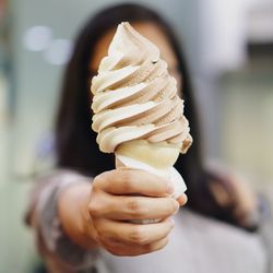 Close-up of hand holding object over white background