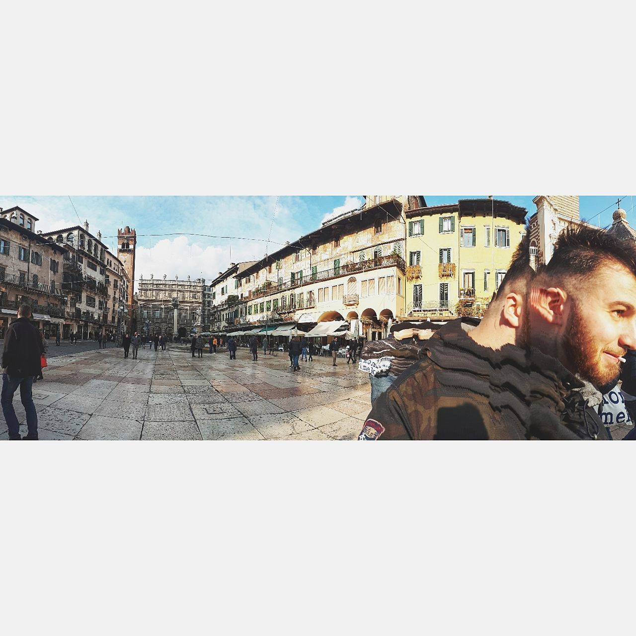 PANORAMIC VIEW OF PEOPLE STANDING BY BUILDINGS AGAINST CLEAR SKY