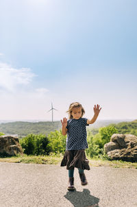 Full length of cute girl standing on land against sky