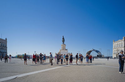 Tourists stop to take photos in the large praça do comércio in lisbon