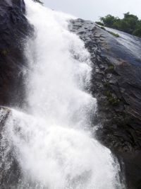 Scenic view of waterfall against sky